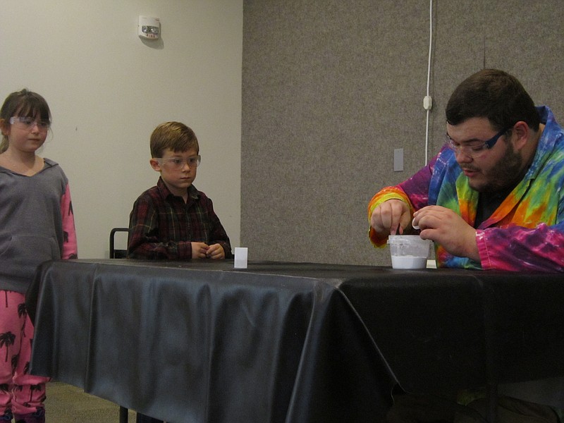 Safety goggles on, Reese Kurtz, 10, and Max Perger, 5, both of Ventnor, lend a hand during th ScienceTellers show.