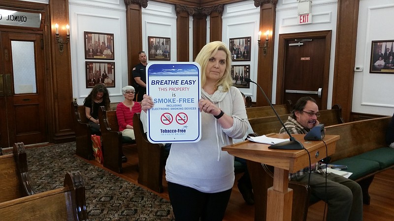 Kim Burns of Atlantic Prevention Resources shows one of the no-smoking signs it provided to Ocean City when it considered its smoking ban.