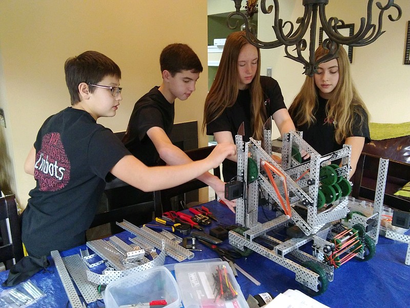 Team Linbots work together Feb. 15 to make sure their robot is ready for a competition. From left, Alex Savov, Nate Fontana, Farley O'Brien and Emma Savov.