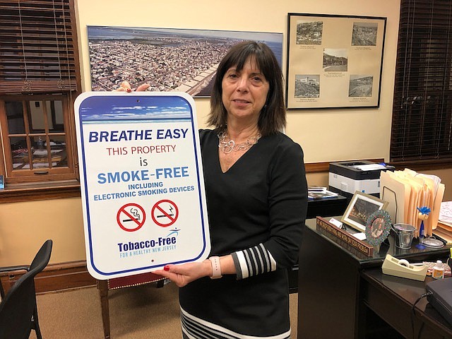 Ventnor City Administrator Maria Mento shows one of the no smoking signs that will be installed on the boardwalk.