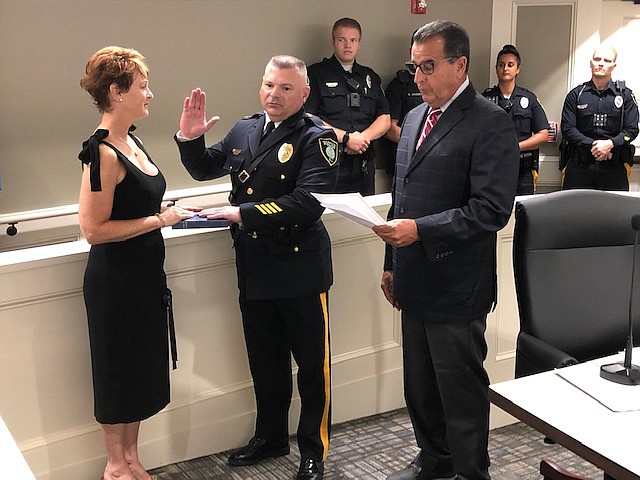 Margate Commissioner of Public Safety John Amodeo administers the oath of office to Capt. Ronald Kashon while his wife Allison holds the Bible.