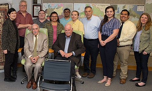 Leon Ullman, seated left, with his brother, Hank, Stockton University faculty, staff and students who worked on the exhibit, and some items from the exhibit.