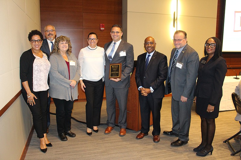 CRDA Executive Director Matthew Doherty, center, with plaque, and his staff, accept the Internship Partner of the Year Award from Stockton Business School Dean Alphonso Ogbuehi (on Doherty's right). 