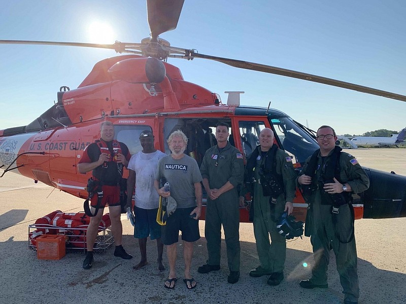 U.S. Coast Guard/Coast Guard aircrews stand with two crewmembers of a vessel that sank 37 miles off Barnegat Light, New Jersey, Jul. 27, 2020. The men requested assistance after their 68-foot fishing vessel began taking on water. 