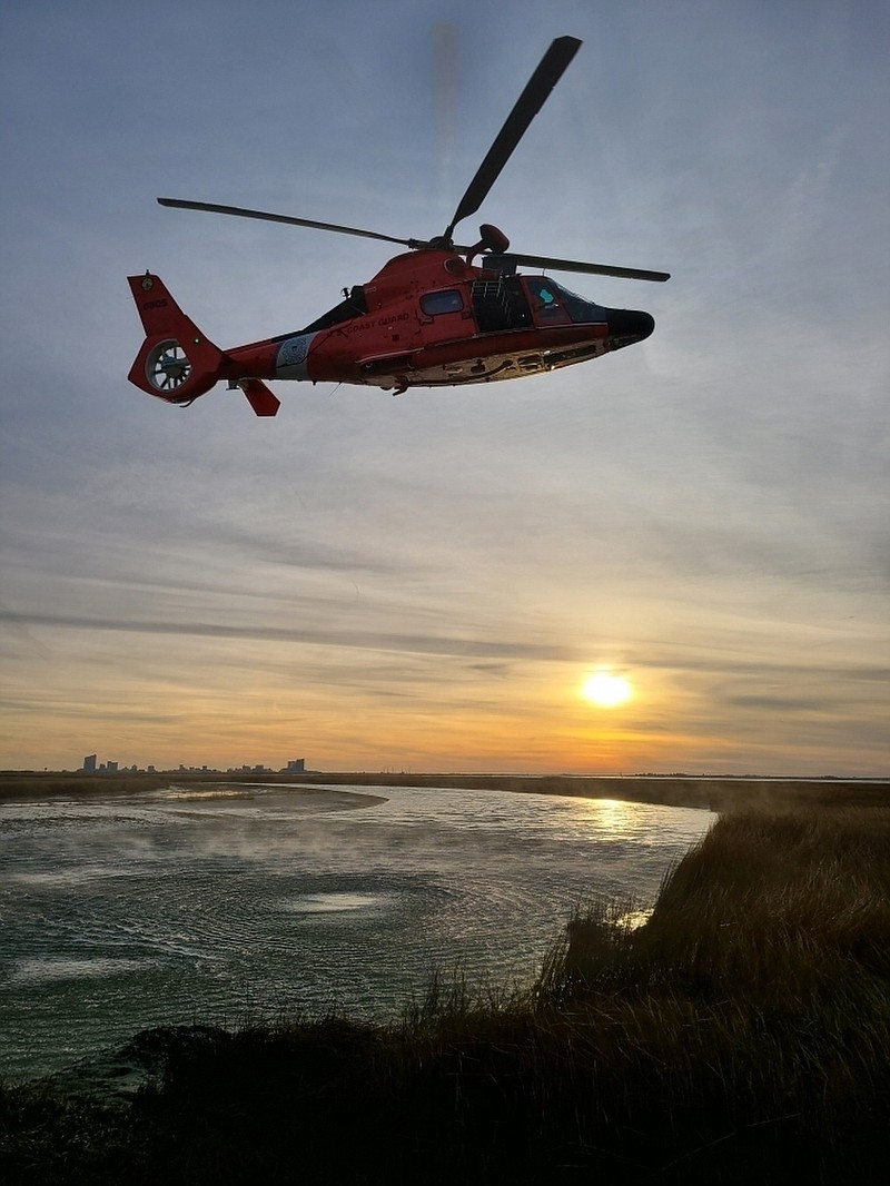 Aircrew from Coast Guard Air Station Atlantic City prepare to lower the basket to retrieve two stranded hunters, Dec. 15, 2020 near Brigantine. The hunters had lost their vessel while hunting and were unable to be reached by boat. (U.S. Coast Guard photo by Petty Officer 3rd Class Roberto Ochoa)
