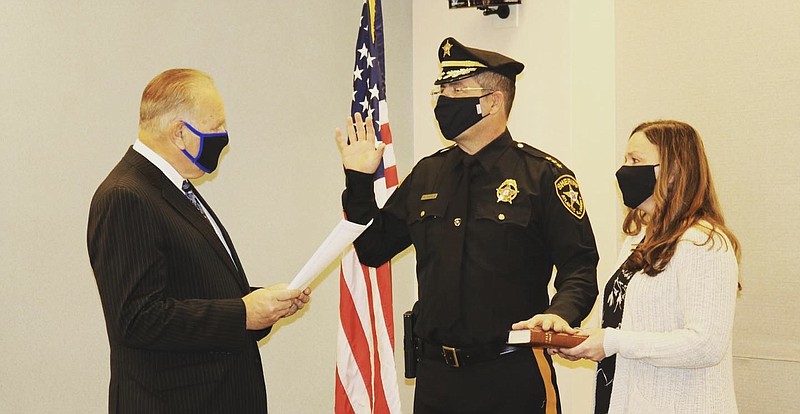 Atlantic County Sheriff Eric Scheffler takes the oath of office administered by Superior Court Judge Michael Donio, Ret., while Scheffler's wife Maria holds the Bible.