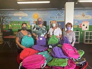 Fox & Roach real estate agents collect and donate filled backpacks to students.