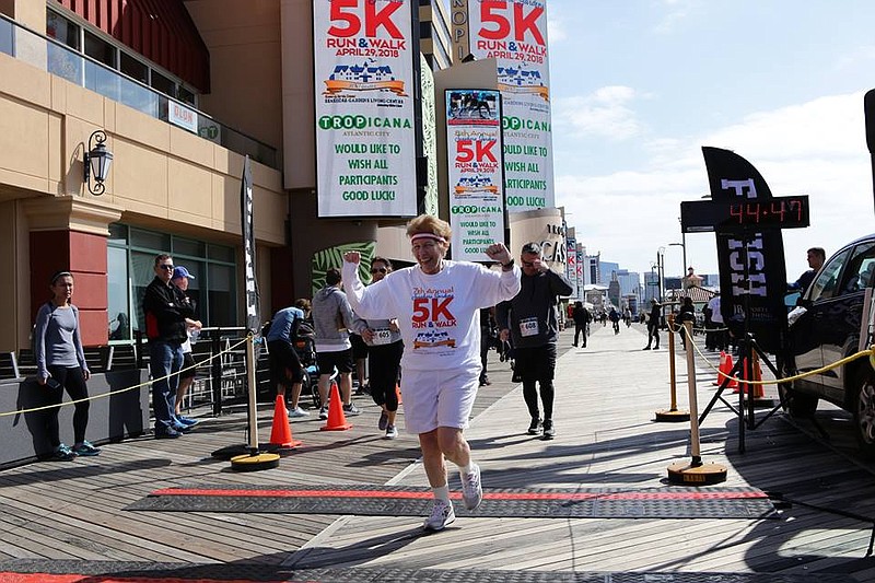 Former SGLC Executive Director Janice Cambron crosses the finish line in a previous Seashore Gardens 5K Run & Health Walk. 