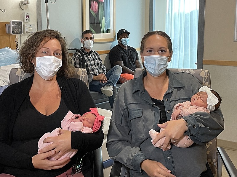 From left, Jennifer Mercado holding baby Sofia Rose and Kerry Player holding baby Karsyn Grace. Their husbands, Rene Mercado and John Jefferson Jr. are in the background.