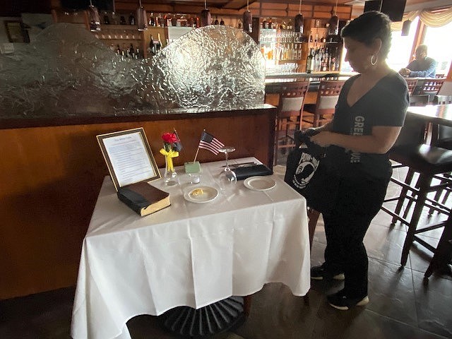 Luann Daleandro, a manager at Ventura's Greenhouse in Margte, polishes the silver for The White Table.