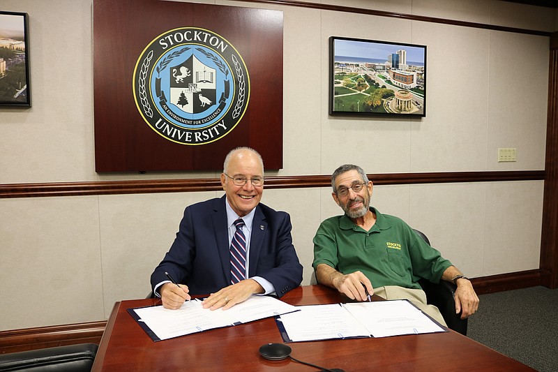 Provided/Stockton University President Harvey Kesselman, left, and Professor Emeritus Michael Frank sign an agreement establishing The Michael and Maureen Frank Award for Excellence in Undergraduate Research in Psychology.