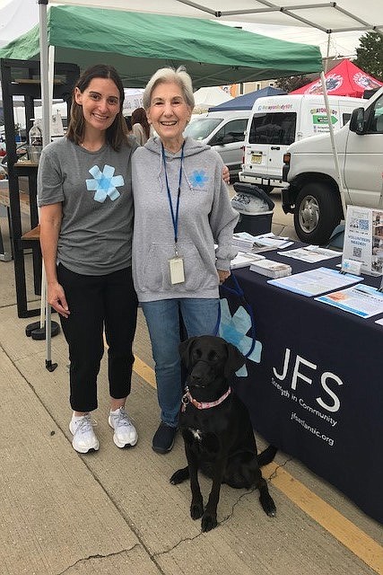 Provided/Valerie Braunstein and Tina Serota host a JFS Lynn Kramer Village by the Shore table at the Ventnor Farmer's Market on June 16 with friendly pup Izzy. Attendees picked up information about the Village, JFS programs and services and volunteer opportunities. 