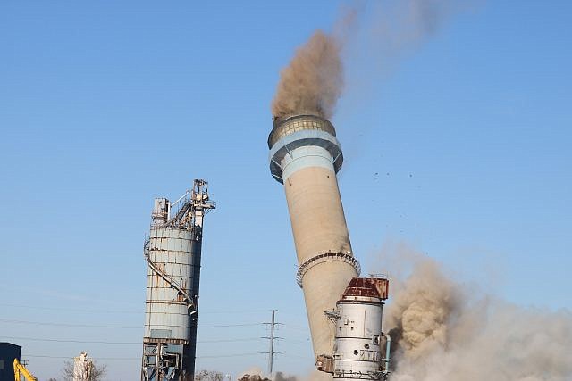 The smokestack tumbles to the ground in just seconds.