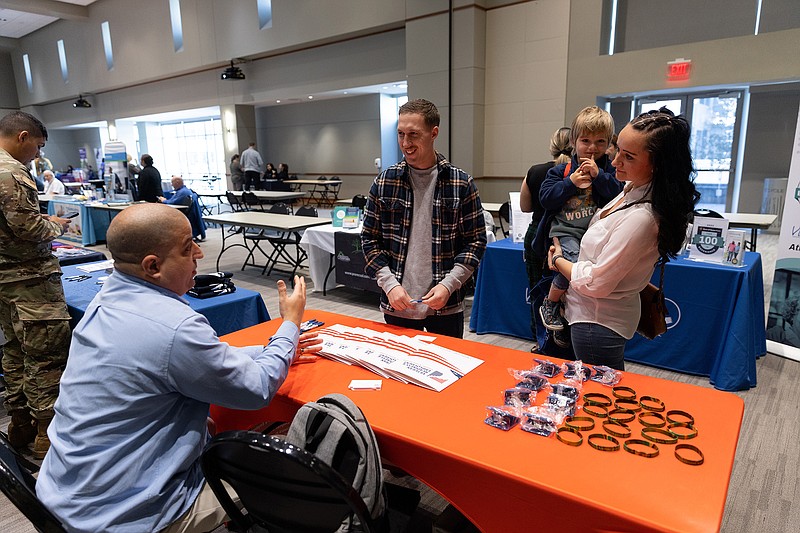 Provided/Dallin Matthews, center, with his wife, Samantha, and their son, Raylan, talk with someone from Veterans Affairs during the inaugural Community and Veteran Wellness and Resource Fair on March 16 at Stockton's Galloway campus.