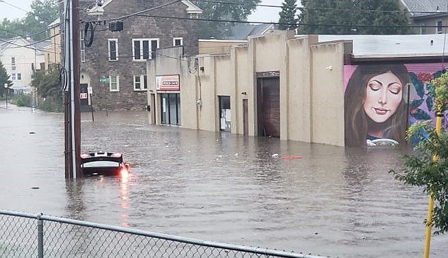 A vehicle is nearly fully submerged due to flooding at the intersection of Third and Walnut streets in Lansdale Borough. 