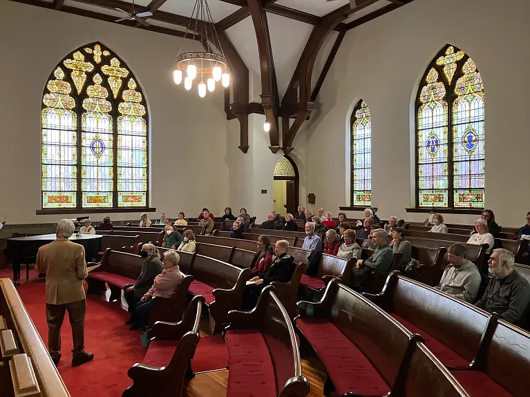 Jon Leight, musical director for St. Luke’s Church in North Wales, speaks to residents and church members during an organ performance in January 2023.