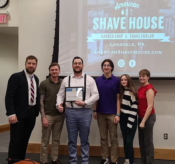 Ryan Adams, center, owner of The American Shave House in Lansdale, receives the borough’s Business of the Month award from councilman BJ Breish, left,