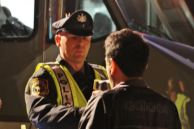 A suspected DUI driver blows into a portable breath test at a checkpoint in Newtown Township, Bucks County. 