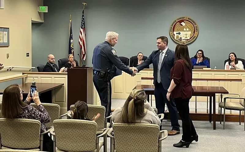 Upper Gwynedd police Chief David Duffy, center left, shakes hands with Detective Jon Gill as he and Officer Dana Hallam were recognized during the tow