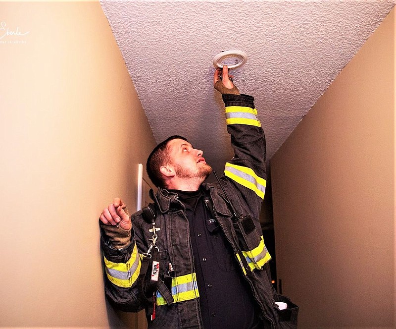 A member of the Towamencin Volunteer Fire Company installs a smoke detector. 