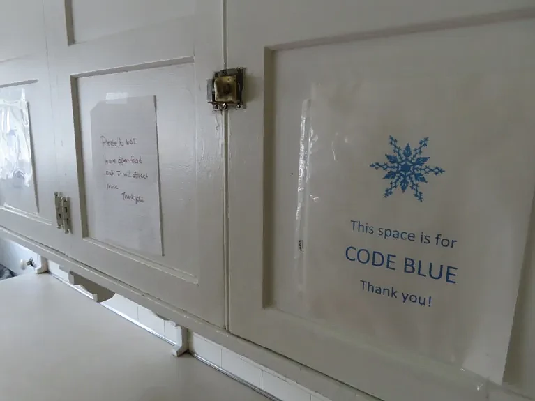 Signs indicating cabinets are reserved for Code Blue shelter materials are seen in the Code Blue shelter at Trinity Lutheran Church’s Luther Hall on T