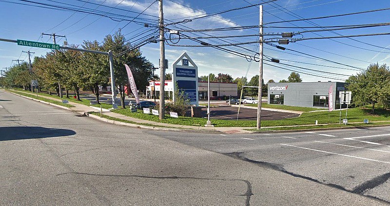 A street-view image of the shopping center, prior to the removal of the trees. 