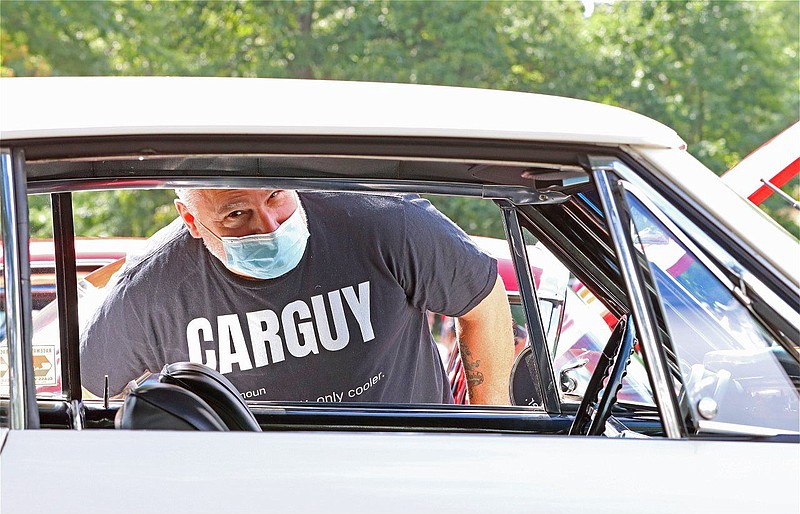 A car enthusiast looks into a vehicle at a car show in Upper Gwynedd in September 2020. 