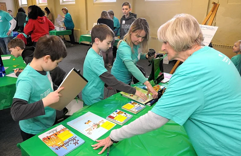 Volunteers assemble “Welcome to America” bags, which include bilingual books, toys and crayons, as part of the Martin Luther King Day of Service at St