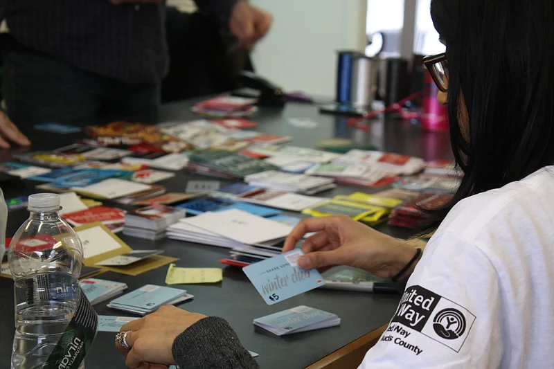 Volunteers pack donated gift cards. 