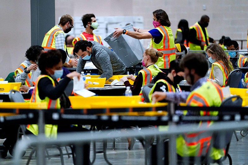 Election workers process mail-in and absentee ballots for the general election Nov. 3, 2020, at the Pennsylvania Convention Center in Philadelphia. 