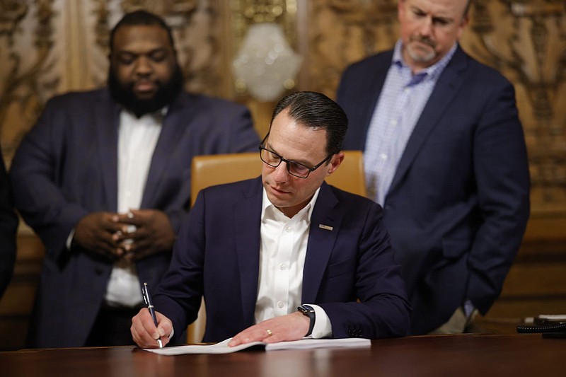 Gov. Josh Shapiro signs the final pieces of the 2023 Pennsylvania budget in the Capitol. 