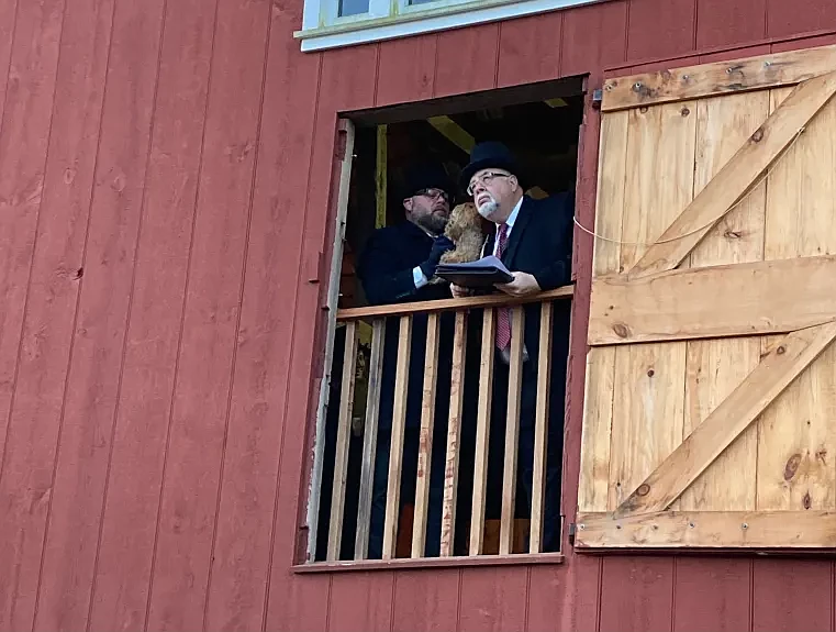 Harleysville Order of the Grundsow (HOG) Schreiber Randy Nyce holds Harleysville Hank as he “whispers” his prediction in the ear of Hauptman Steven Hu