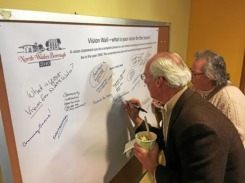 North Wales residents Mike Fellmeth and Judy Miller write ideas on a vision wall during a “North Wales 2040” community forum in 2017 to gather feedbac