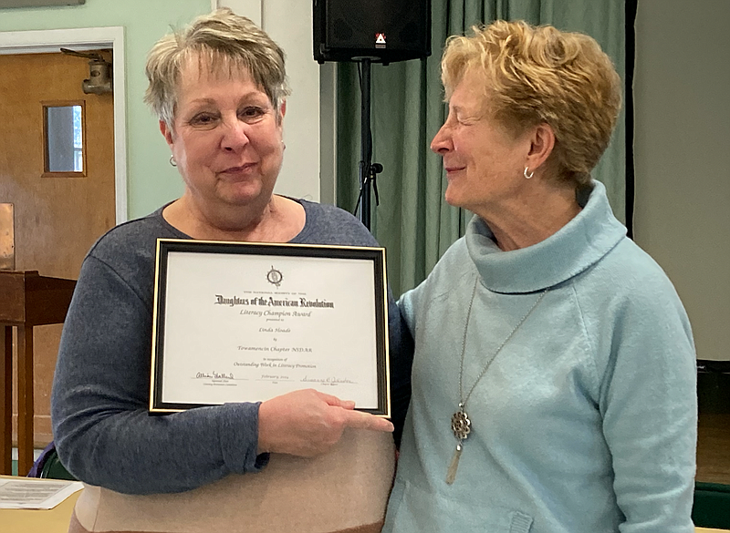 Linda Hoade, left, is presented with the DAR Literacy Champion Award by Towamencin Chapter member Ruth Baltozer. 