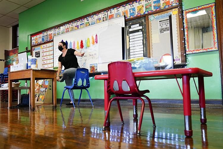 Teacher Tara Matise exercises with her prekindergarten students participating virtually in her classroom ahead of planned in-person learning at Nebing