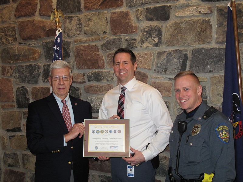 Chief Scott Bendig, center, and Officer Daniel Rose, right, accept the Seven Seals Award. 