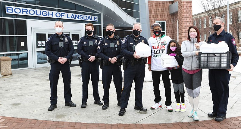 Members of the Lansdale Borough Police Department are joined by local activist Shaheer Johnson, his daughter, Destiny Johnson, and Lansdale Tavern own