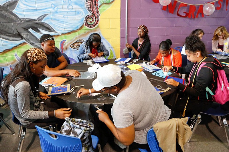 Students from Mastery Charter School-Pickett Campus in Philadelphia decorate their graduation caps June 13, 2018. 