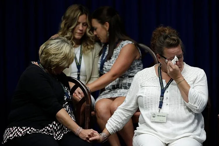 In this Aug. 14, 2018, file photo, victims of clergy sexual abuse, or their family members, react as then-Pennsylvania Attorney General Josh Shapiro s