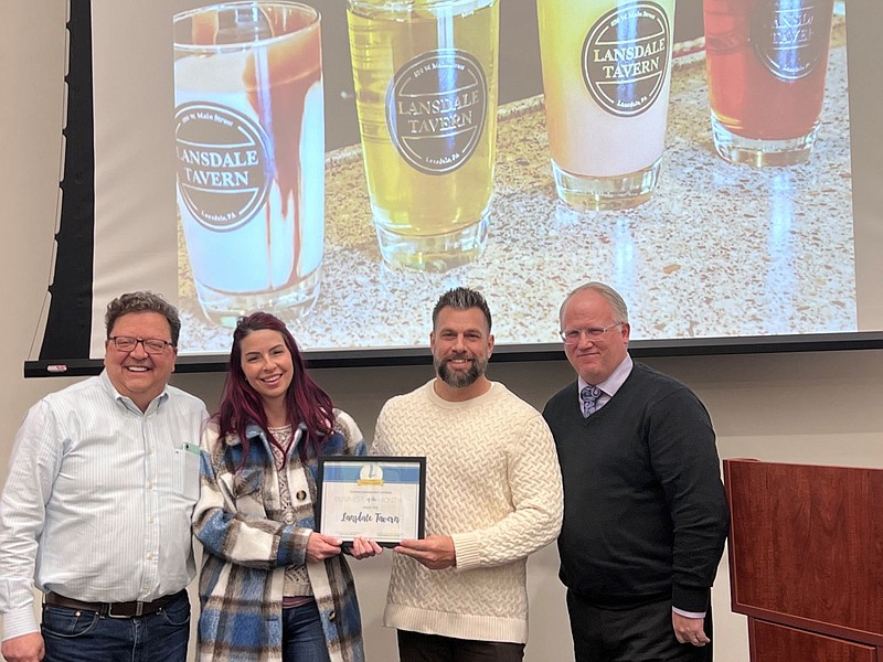 Sign-A-Rama owner Pete Naber, left, presents the award to Lansdale Tavern owner’s Julie Palermo, center left, and Buddy Harris, center right, with Lan