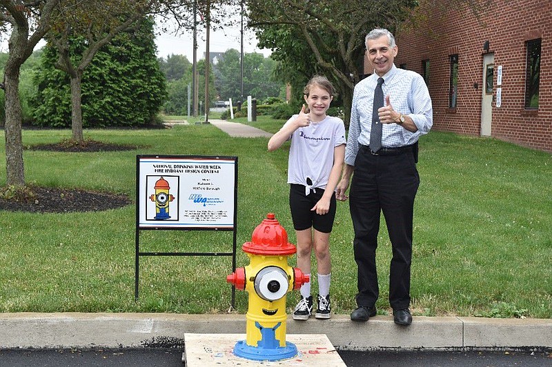 Kalissie Loftus, center, stands with her winning design and North Penn Water Authority Executive Director Anthony Bellitto Jr. 