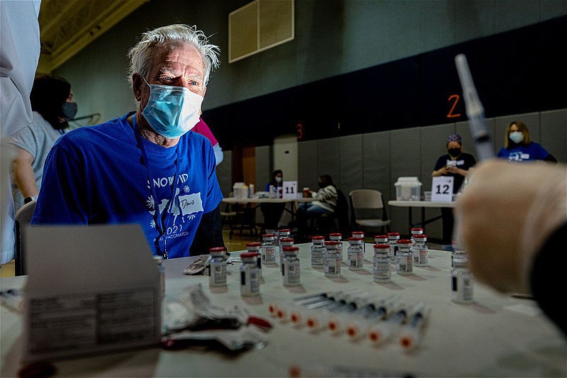 A man waits for his vaccine at a pop-up vaccination clinic held by Skippack Pharmacy at North Penn High School. 