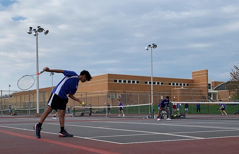 Nikhil Madaka (12) preparing a serve during a doubles match, assisted by Jigar Dadarwala (12) at an April 15 match. 