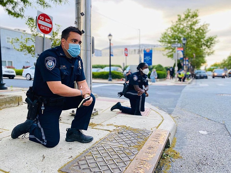 Lansdale Borough Police officers Chad Bruckner, left, Hazel Bundy, center, and Chief Michael Trail far right, kneel with protestors on June 2, 2020, d