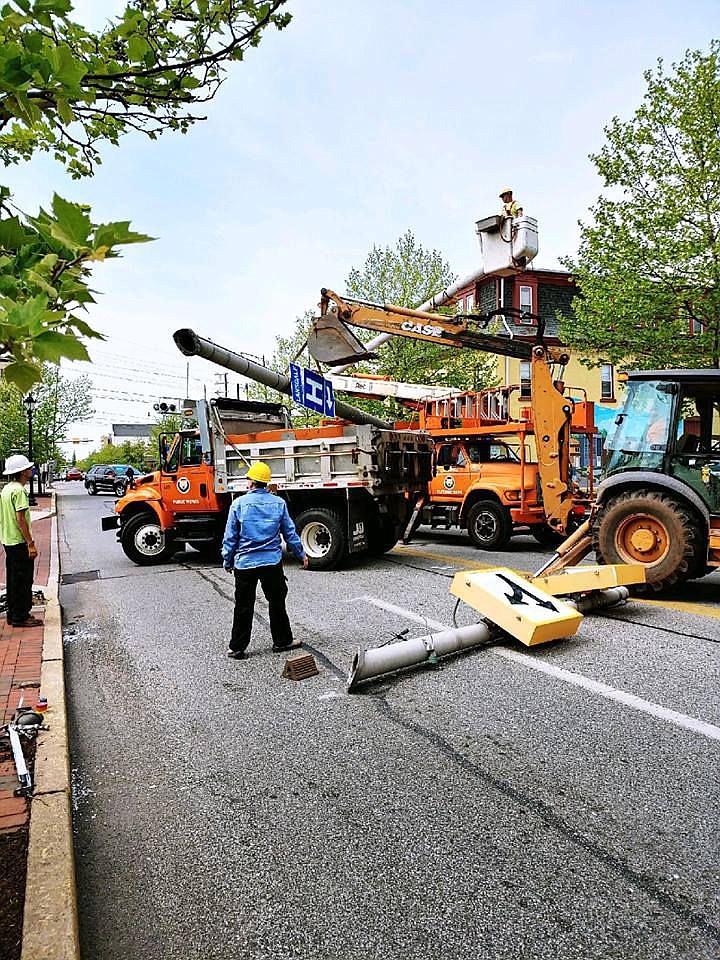 Crews work to clear the scene of a downed pole on Monday afternoon. 