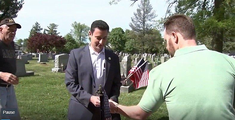 Montgomery County Commissioner Joe Gale hands out flags to place on veterans’ graves at Saint Matthews Cemetery in Conshohocken on May 17. 