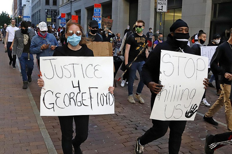 A group marches through the streets of downtown Pittsburgh Sunday, May 31, 2020 protesting the death of George Floyd, who died after being restrained 