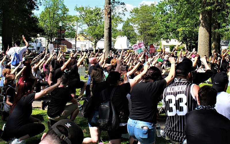 Protesters at Memorial Park in Lansdale take a knee and raise their fists in solidarity. 