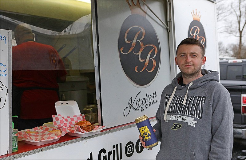 A customer picks up food from the B.B. Kitchen and Grill food truck outside of Ten7 Brewing in North Wales Borough. 