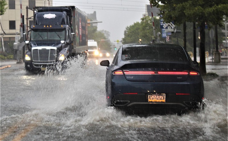 Vehicles travel through flooded waters at the intersection of West Main and Walnut streets in Lansdale Borough. 